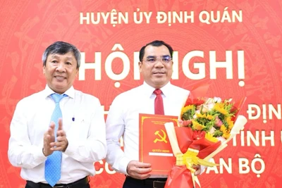 Phó Bí thư Thường trực Tỉnh ủy Hồ Thanh Sơn trao quyết định và tặng hoa chúc mừng tân Bí thư Huyện ủy Định Quán.