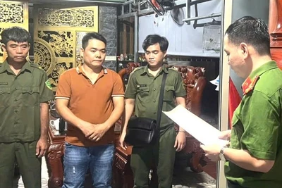 Cơ quan điều tra thi hành lệnh khám xét tại nhà Nguyễn Bá Thanh (áo nâu). (Ảnh: Công an tỉnh Đồng Nai)