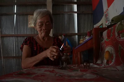 Bà Lê Thị Lời thắp sáng bằng đèn dầu mỗi buổi tối do điện chưa được kéo về tuyến kênh Năm Châu.