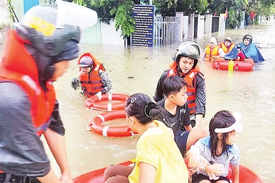 Cảnh sát cơ động Công an thành phố Ðà Nẵng di dời người dân Tổ 129, phường Hòa Minh, quận Liên Chiểu đi tránh lũ sáng 14/10. 