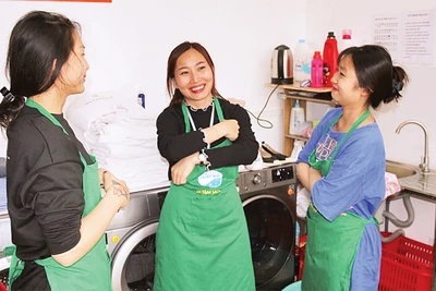 Lương Thị Kiều Thúy (người đứng giữa) trao đổi công việc cùng các đồng nghiệp. 