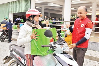 Hội viên Hội Chữ thập đỏ hỗ trợ người dân mua hàng ở Chợ Tết Nhân ái tại Ðà Nẵng. (Ảnh THANH TÂM) 
