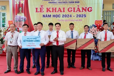 Phó Thủ tướng Lê Thành Long (phải) tặng 5 bộ máy vi tính cho Trường tiểu học và trung học cơ sở Tuân Đạo, huyện Lạc Sơn.