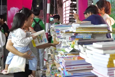 Một cháu bé đi cùng mẹ tại Ngày sách và văn hóa đọc tỉnh Đồng Tháp. (Ảnh: HỮU NGHĨA)