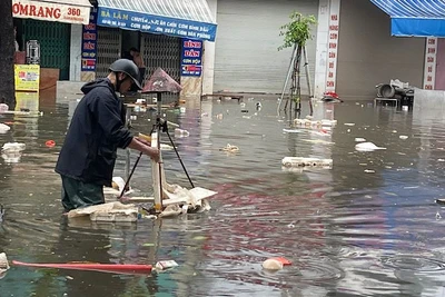 Nhân viên Công ty TNHH MTV Công trình đô thị Nam Định vớt rác trôi nổi, tiêu thoát nước úng ngập trên đường Trần Hưng Đạo, thành phố Nam Định.