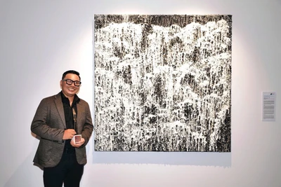 Họa sĩ Nguyễn Việt Cường bên bức tranh thắng giải.