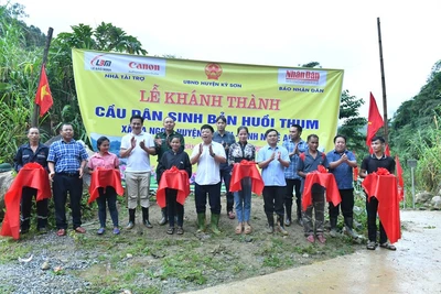 Phó Tổng Biên tập Báo Nhân Dân Quế Đình Nguyên cùng đại diện lãnh đạo chính quyền địa phương, và đơn vị đồng hành cắt băng khánh thành cầu dân sinh bản Huổi Thum, xã Na Ngoi (Kỳ Sơn). (Ảnh Đăng Khoa)