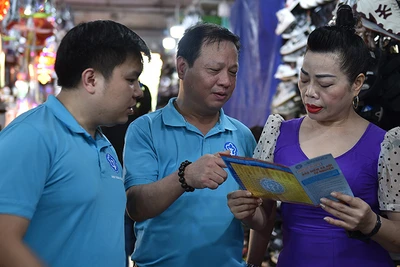 Cán bộ Bảo hiểm xã hội Hà Nội vận động người dân tham gia bảo hiểm xã hội tự nguyện, bảo hiểm y tế hộ gia đình. (Ảnh HSS)