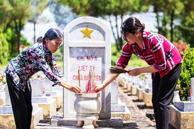 Người dân thắp hương ở khu mộ liệt sĩ chưa xác định thông tin. Ảnh: HOÀNG TÁO