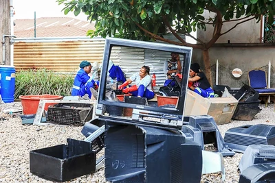 Phụ nữ ở Cameroon lau chùi vỏ ti-vi bỏ đi ở Yaounde. Ảnh: GETTY