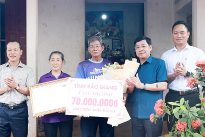 Bí thư Tỉnh ủy Bắc Giang Dương Văn Thái (thứ 2, phải sang) tặng quà cho đại diện gia đình vận động viên Nguyễn Thị Oanh.