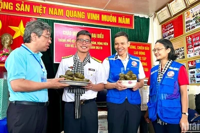 Đồng chí Nguyễn Phước Lộc, Phó Bí thư Thành ủy, Chủ tịch Ủy ban Mặt trận Tổ quốc Việt Nam Thành phố Hồ Chí Minh (bên trái) trao bánh giò mới nấu đến cán bộ, chiến sĩ trên nhà giàn DK1/10.