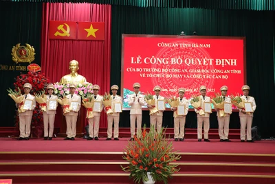 Đồng chí Giám đốc Công an tỉnh Hà Nam trao quyết định, tặng hoa chúc mừng các đồng chí lãnh đạo cấp phòng nhận công tác mới.