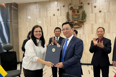 Phó Chủ tịch Liên hiệp các tổ chức hữu nghị Việt Nam Đồng Huy Cương và Chủ tịch Viện Simon Bolivar vì Hòa bình và Đoàn kết giữa các dân tộc Rosa Eekhout Gómez ký kết Bản ghi nhớ hợp tác. (Ảnh: Đại sứ quán Việt Nam tại Venezuela)