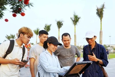 Nhiều du khách hào hứng thử nghiệm check-in với bảng gắn chip NFC tại Quảng trường Hồ Chí Minh.