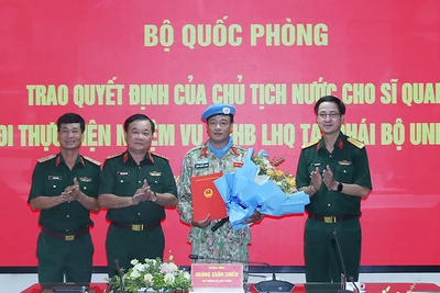 Thượng tướng Hoàng Xuân Chiến trao Quyết định của Chủ tịch nước và tặng hoa chúc mừng Trung tá Đặng Quốc Tuấn. 