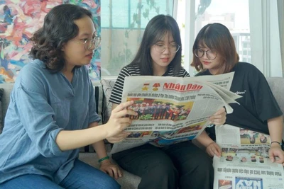 Các bạn trẻ tại Thành phố Hồ Chí Minh đón đọc Báo Nhân Dân. (Ảnh: THẾ ANH)