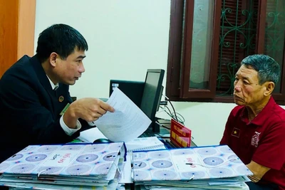 Cán bộ Tòa án nhân dân huyện Lý Nhân, tỉnh Hà Nam giải thích quy định pháp luật cho người dân. (Ảnh HẢI ĐĂNG)