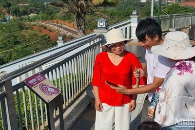 Hướng dẫn du khách thực hiện các thao tác check in trên bảng gắn chip NFC đặt tại thành phố Gia Nghĩa, tỉnh Đắk Nông.