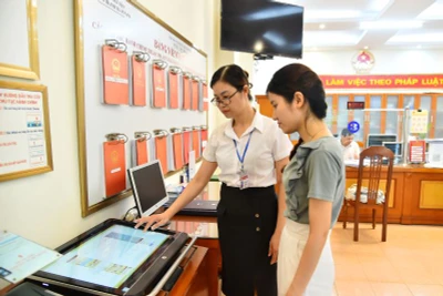 Cán bộ Ủy ban nhân dân phường Thanh Xuân Nam (quận Thanh Xuân, Hà Nội) hướng dẫn người dân thực hiện thủ tục hành chính trên môi trường mạng. Ảnh: Thuỷ Nguyên.