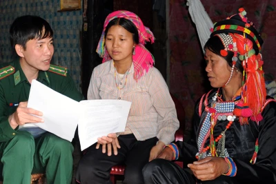 Cán bộ Ðồn Biên phòng Ka Lăng (Lai Châu) đến nhà người dân tuyên truyền phòng chống mua bán người. (Ảnh LÂM THANH) 