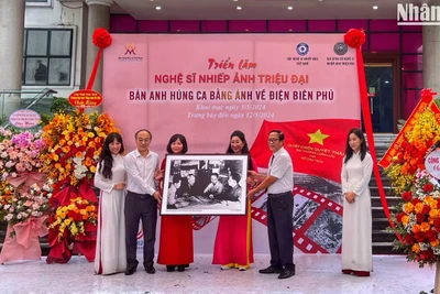Đạo diễn Triệu Tuấn (người cầm ảnh bên phải) đại diện gia đình cố Nghệ sĩ nhiếp ảnh Triệu Đại trao tặng bộ ảnh cho Bảo tàng Phụ nữ Việt Nam.