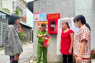 Công an phường Tân Chánh Hiệp (Quận 12, Thành phố Hồ Chí Minh) hướng dẫn người dân sử dụng bình chữa cháy để bảo đảm Tổ liên gia phòng cháy, chữa cháy hoạt động hiệu quả.