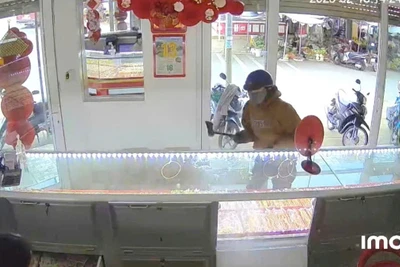 Hình ảnh đối tượng dùng rìu phá tủ kính cướp tiệm vàng được camera an ninh ghi lại.