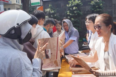 Lãnh đạo, phóng viên Cơ quan đại diện Báo Nhân Dân tại khu vực miền nam trao phụ san đặc biệt cho bạn đọc.