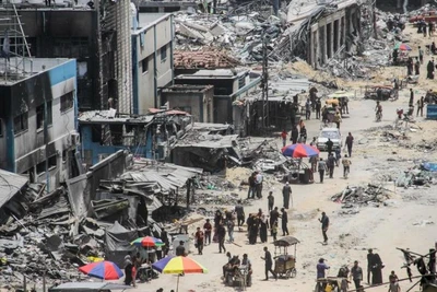 Người dân trên một con phố có những tòa nhà bị phá hủy, tại trại Jabalia, ở phía bắc Dải Gaza. (Ảnh: Tân Hoa xã)