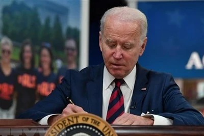 Tổng thống Mỹ Joe Biden ký một đạo luật tại Nhà Trắng. (Ảnh: AFP/TTXVN)