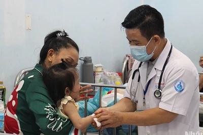 Bác sĩ Bệnh viện Nhi đồng 1 đang khám cho trẻ mắc tay chân miệng (Ảnh: Thế Anh)