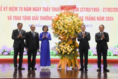 Đồng chí Nguyễn Văn Quảng, Ủy viên Ban Chấp hành Trung ương Đảng, Bí thư Thành ủy, Trưởng đoàn Đại biểu Quốc hội đơn vị thành phố Đà Nẵng và Phó Bí thư Thường trực Thành ủy Nguyễn Đình Vĩnh trao tặng lẵng hoa chúc mừng Ngành y tế Đà Nẵng nhân ngày 27/2. (Ảnh: ANH ĐÀO)