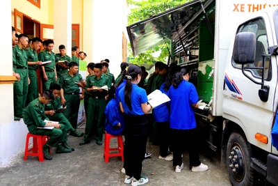 Các chiến sĩ và thanh niên địa phương tìm kiếm nhiều đầu sách trên xe thư viện lưu động.