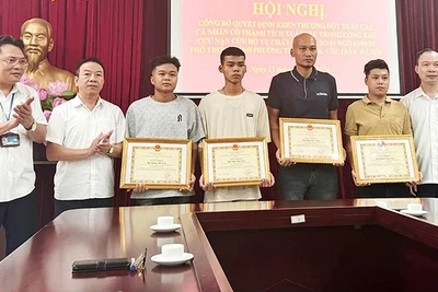 Đồng Văn Tuấn và Hoàng Anh Tuấn (thứ 4 và 5 từ phải sang) cùng các cá nhân tiêu biểu nhận Bằng khen của Ủy ban nhân dân quận Cầu Giấy sau vụ cháy ở phố Trung Kính.