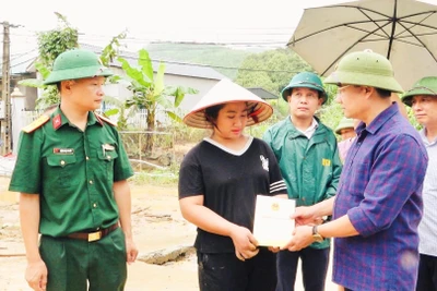 Chủ tịch Ủy ban nhân dân huyện Văn Yên Hà Đức Anh trao hỗ trợ cho người dân bị thiệt hại đổ nhà do mưa bão. (Ảnh: THANH SƠN)