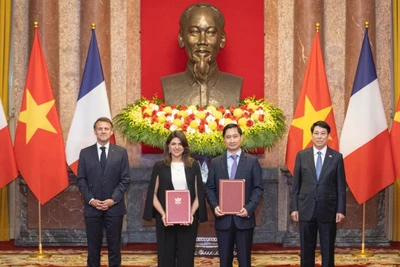 Ông Ngô Chí Dũng, Tổng Giám đốc kiêm Chủ tịch HĐQT Công ty Vaccine Việt Nam (VNVC) và bà Zainab Sadat Qayyum, Chủ tịch Sanofi Đông Nam Á-Ấn Độ trao văn kiện thỏa thuận hợp tác chuyển giao công nghệ sản xuất vaccine của Sanofi tại Nhà máy Vaccine và Sinh phẩm VNVC trước sự chứng kiến của Chủ tịch nước Lương Cường và Tổng thống Pháp Emmanuel Macron. (Ảnh: SƠN TÙNG)