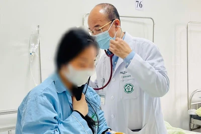 Bác sĩ khám cho sản phụ bị mắc cúm. 