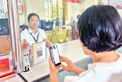 Người dân xã Tân Thành (huyện Kim Sơn, tỉnh Ninh Bình) thanh toán lệ phí qua ứng dụng thanh toán điện tử trên điện thoại di động.