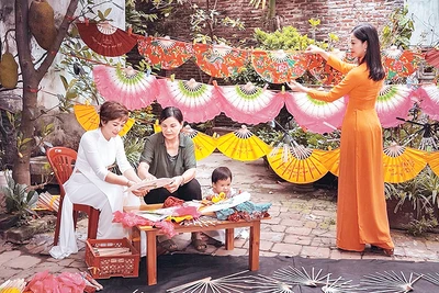 Nghệ nhân Nguyễn Thị Tuấn (áo sẫm) giới thiệu về nét đẹp quạt Chàng Sơn đến khách du lịch.