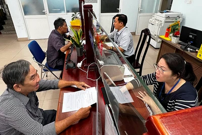 Người dân thực hiện thủ tục hành chính tại Ủy ban nhân dân Phường 6 (quận Bình Thạnh, Thành phố Hồ Chí Minh) trước thời điểm phường này sáp nhập với Phường 7. (Ảnh QUANG QUÝ)