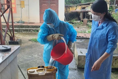 Cán bộ Trung tâm Dịch vụ Nông nghiệp huyện Phúc Thọ, Hà Nội pha hóa chất, phun khử trùng, phòng chống dịch bệnh gia súc, gia cầm sau bão số 3.