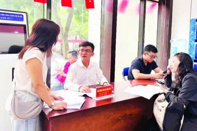 Cán bộ Trung tâm Phục vụ hành chính công-Chi nhánh số 7 hướng dẫn người dân hoàn thiện hồ sơ trước khi vào cửa tiếp nhận.