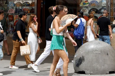 Người dân di chuyển dưới trời nắng nóng tại Madrid, Tây Ban Nha. (Ảnh: AFP/TTXVN)