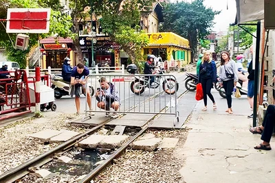 Khách nước ngoài chụp ảnh đường tàu ở khu vực ngoài rào chắn.