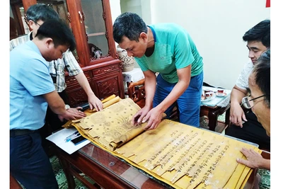 Nhà sưu tập Đặng Vũ Khương cùng đại diện người dân Tri Chỉ kiểm tra tình trạng sắc phong. Ảnh: NCVV