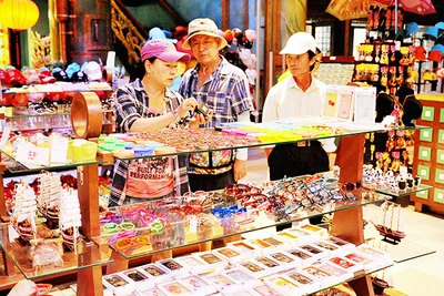 Du khách mua đồ lưu niệm tại một cửa hàng ở Đà Nẵng. Ảnh: NGUYỆT ANH