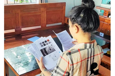 Chị Trần Thị Vy cùng với hồ sơ bệnh án tai biến do tiêm nâng mũi.