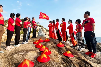 Du khách chào cờ đón ánh bình minh ở Mũi Đôi. Ảnh: THANH AN