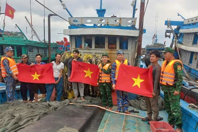 Cán bộ, chiến sĩ BĐBP thành phố Hải Phòng tặng cờ cho ngư bám biển. 